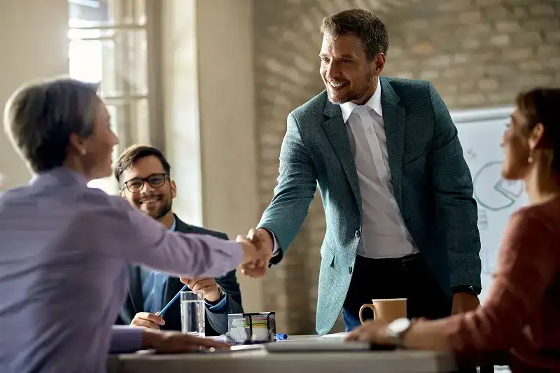 business coworkers shaking hands during meeting office focus is businessman